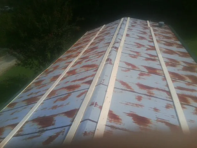 Rusted metal roof panels with new wood purlins before replacement — Storm Damage Roof Repair in Romayor by Roofing Brothers