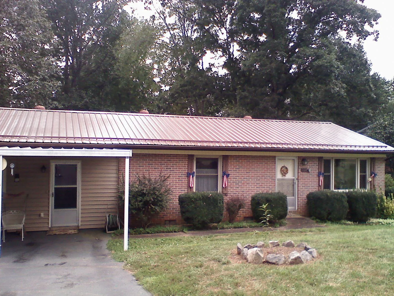 Bronze metal roof and carport on a brick ranch home — Roof Repair work by our crew in Romayor